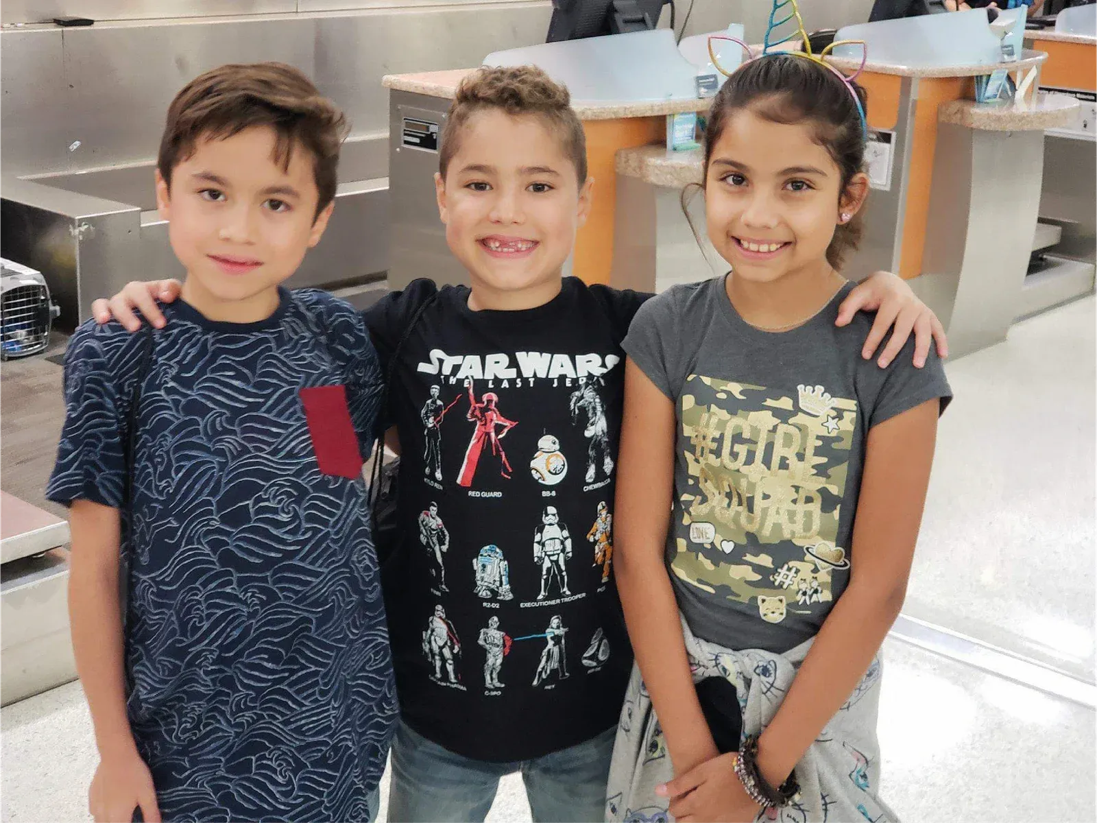Tres niños sonriendo y abrazados